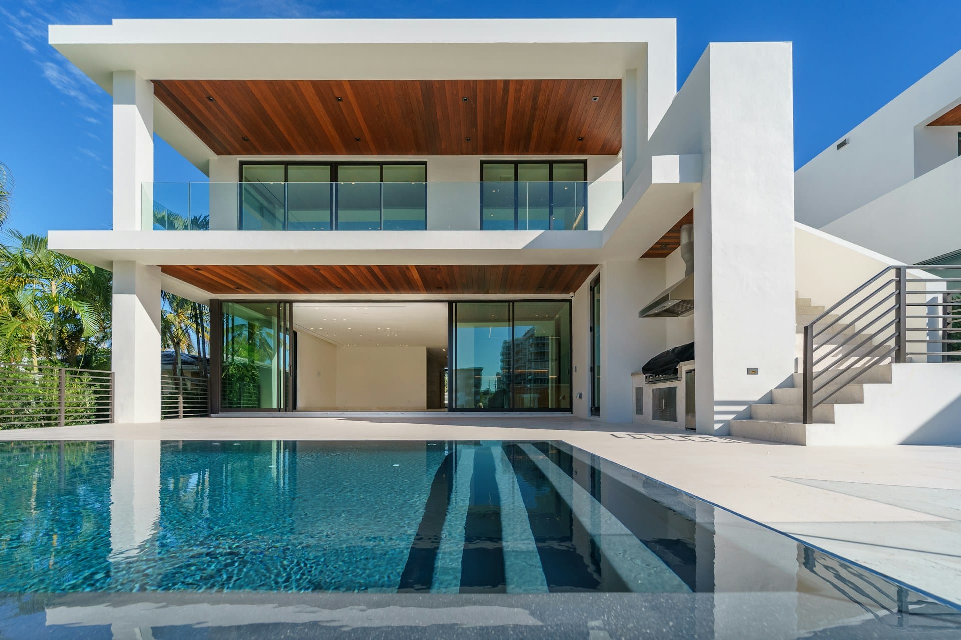 Sunlit contemporary white villa beside a turquoise private pool